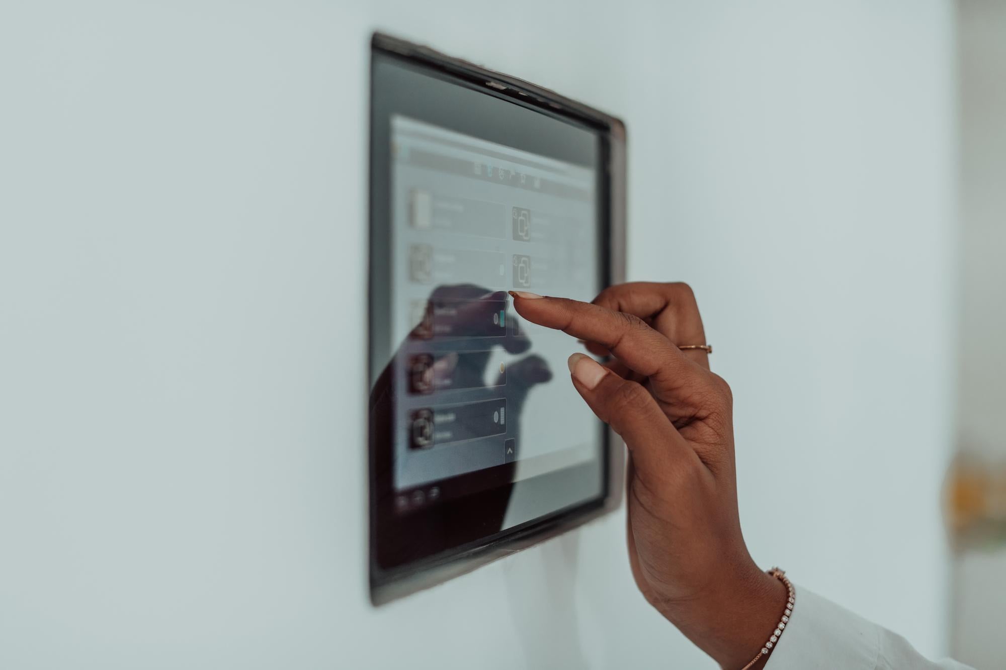 A woman tapping a wall-mounted touch panel